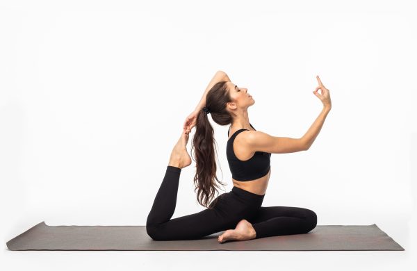 Sporty young woman doing yoga practice isolated on white background - concept of healthy life and natural balance between body and mental development